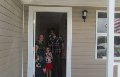 Homeowners standing in doorway of new home