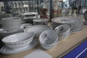 Stacks of vintage china plates, teacups, and bowls displayed on a counter at the Habitat ReStore Sebring