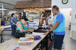 Senior customer browsing affordable books at the Habitat ReStore checkout in Sebring, FL