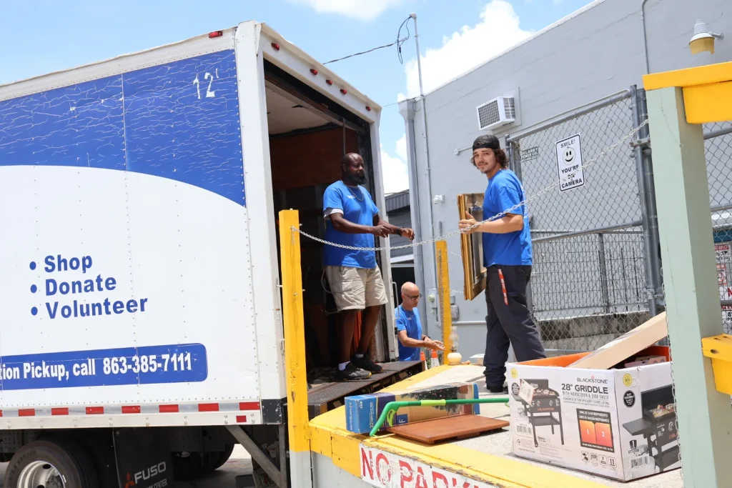 Habitat ReStore donation crew loading donated items onto the Shop Donate Volunteer pickup truck in Sebring