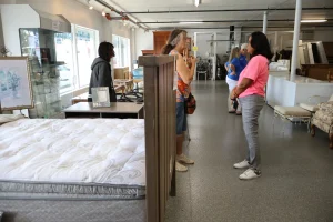 Customers browsing affordable mattresses and showroom furniture at Habitat ReStore Sebring
